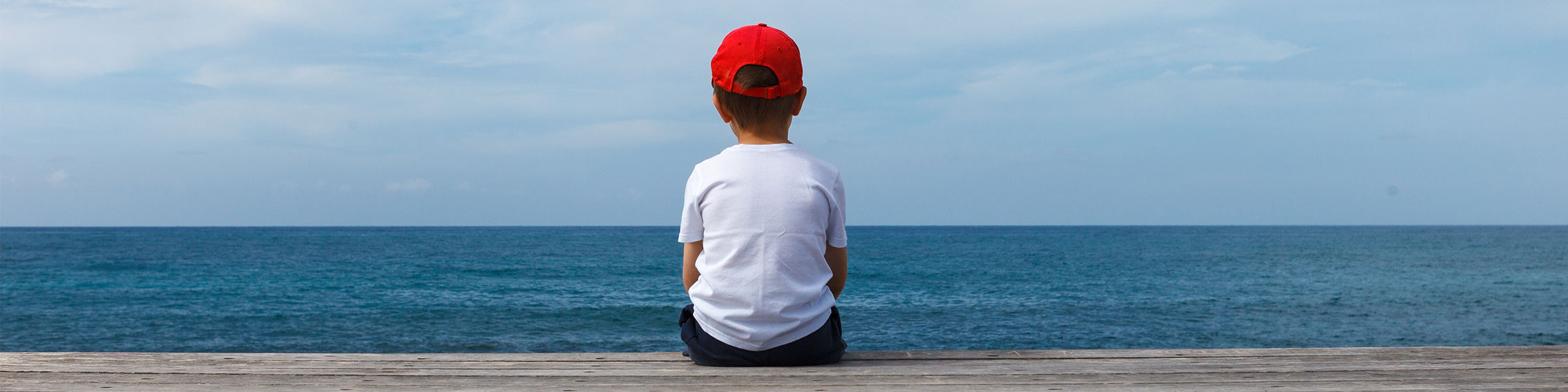 Child looking out over ocean