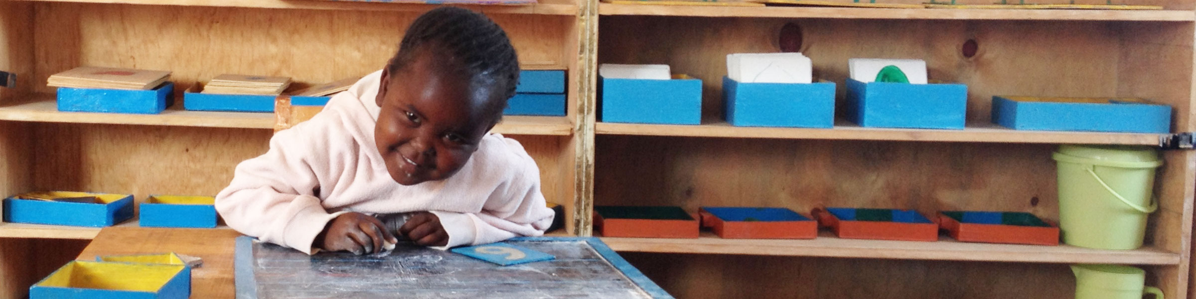 Child tracing sandpaper letters, Corner of Hope, Kenya