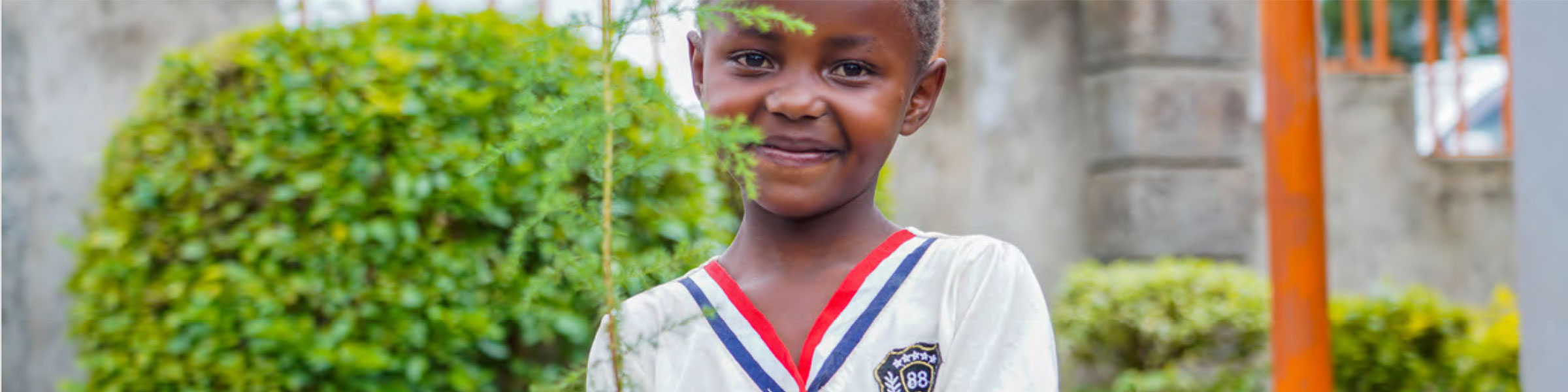 Child planting tree at Corner of Hope, Kenya