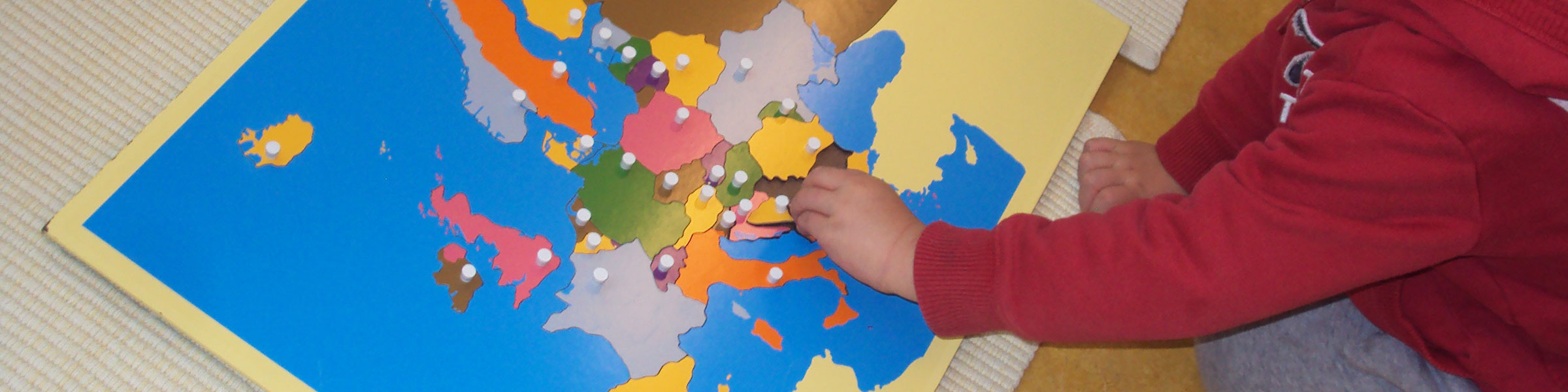 Child on floor with puzzle map