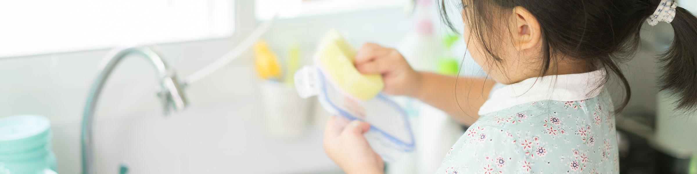 Young child washing dishes