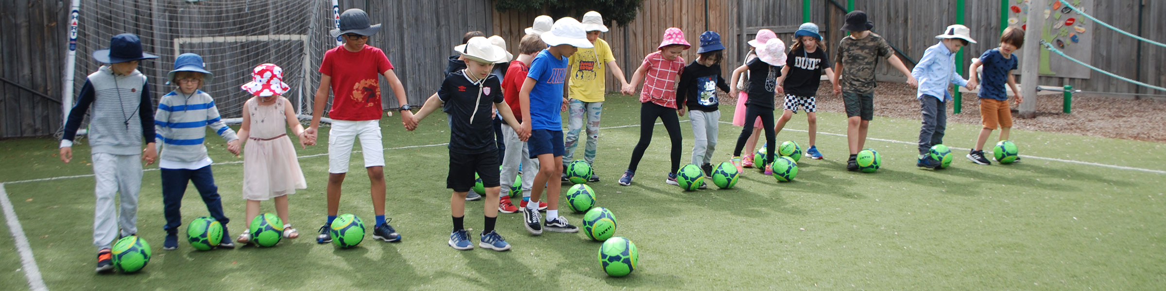 Line of children kicking balls
