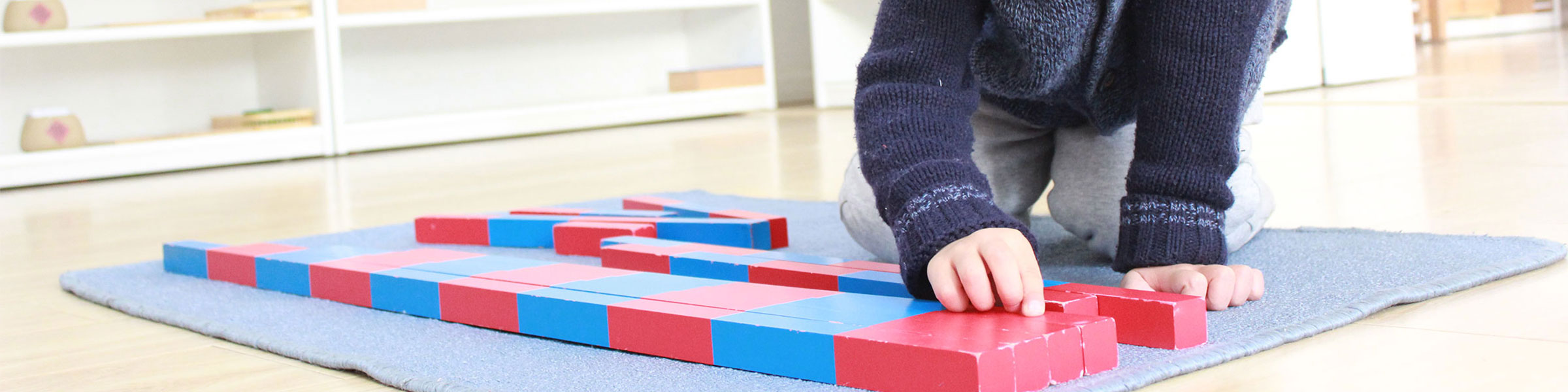 Child using Montessori number rods