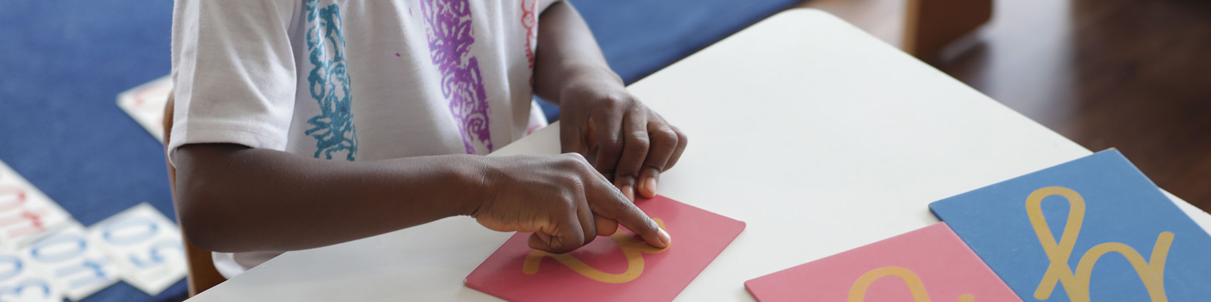 Child tracing sandpaper letters