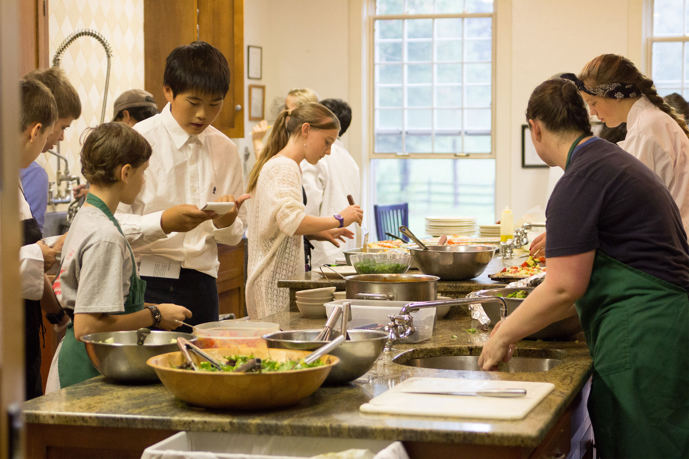 Montessori adolescent students working in a kitchen