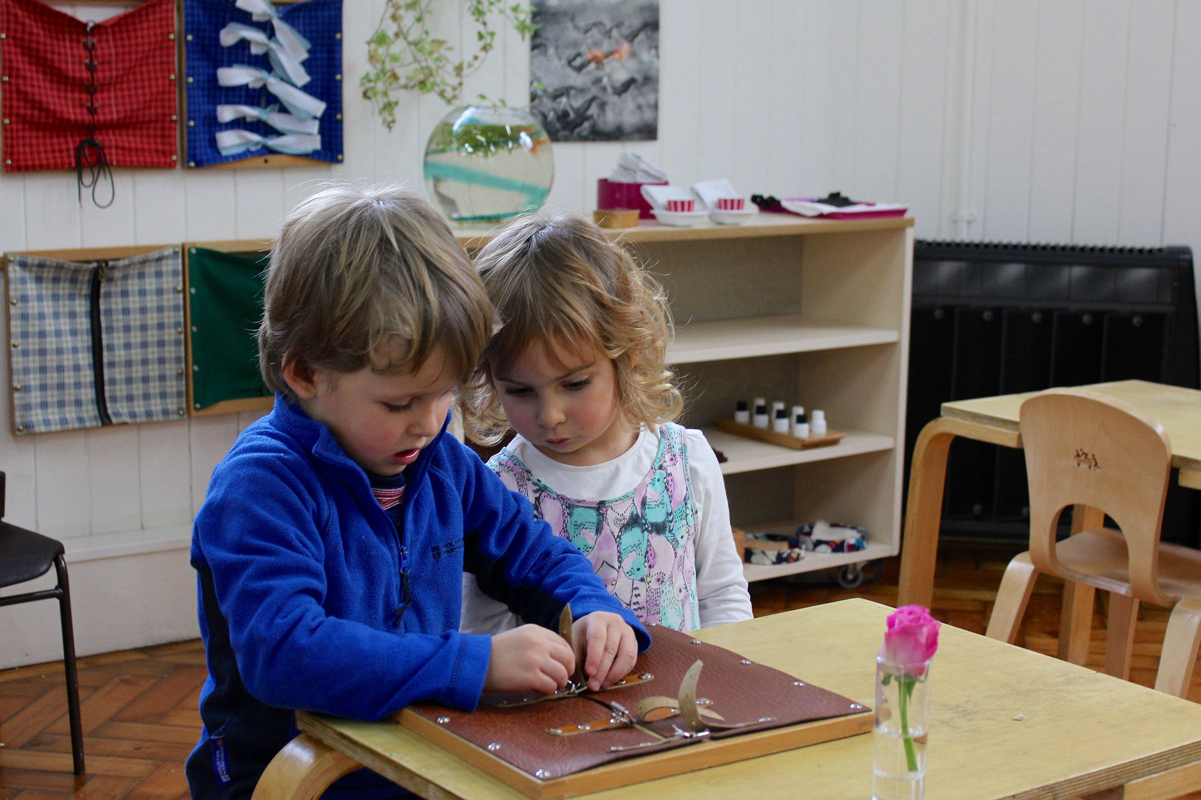Child demonstrating Montessori material to another child