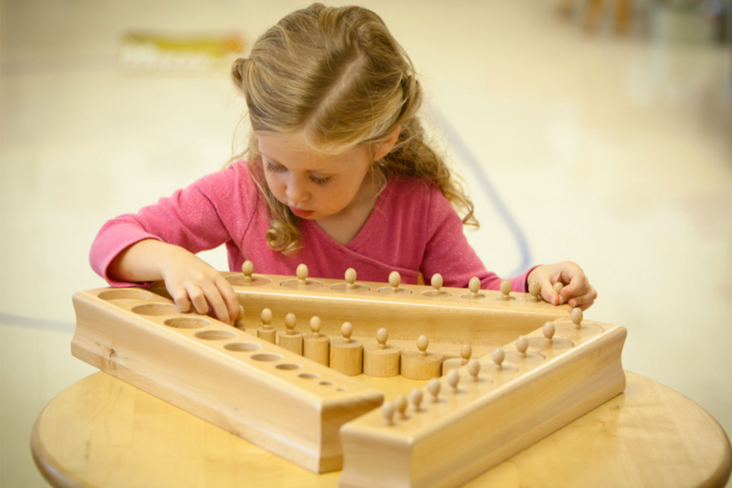 Child working with Montessori cylinder blocks