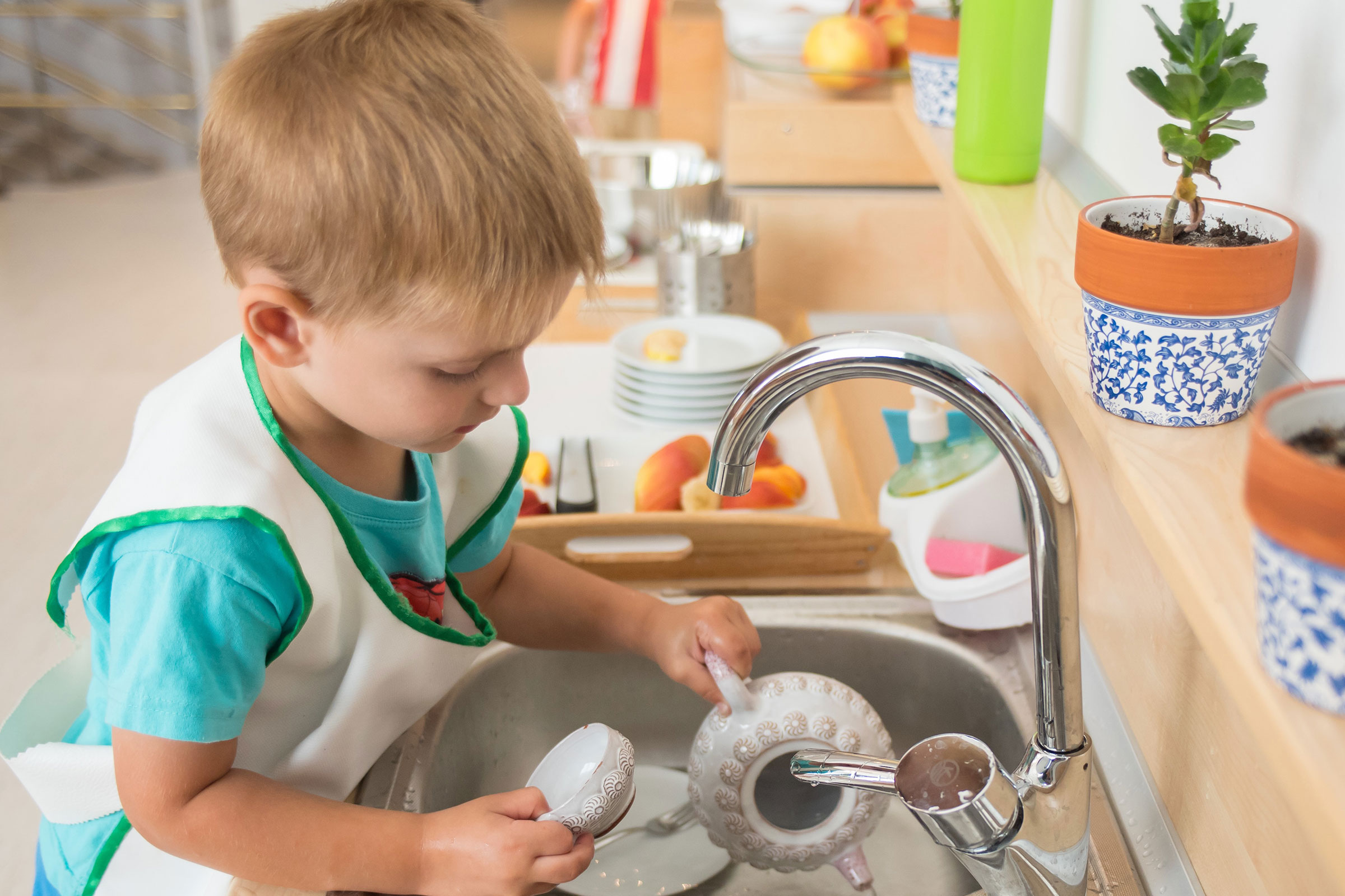 Child washing in sink