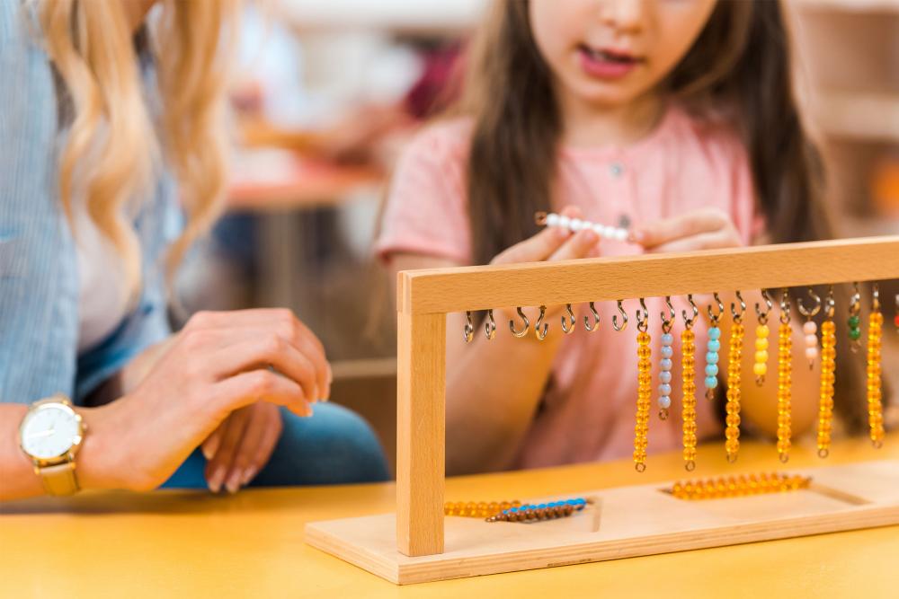 Montessori educator and student with colour beads